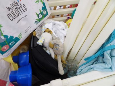 a basket full of baby clothes and toys in it