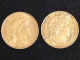 a close up of two gold coins on a black surface