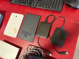 a keyboard, mouse, and other electronics on a red table