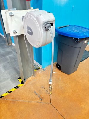 un tuyau fixé sur le mur, à côté d'une poubelle