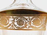 a clear glass vase with a gold decoration on it