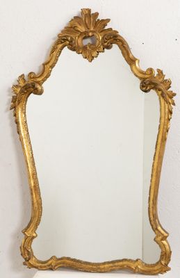 une image d'un miroir encadré d'or sur un mur blanc