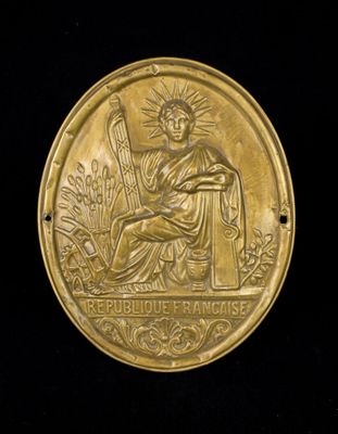 an image of a gold medal with a woman holding a harp