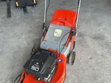 a red lawn mower that is sitting in the garage
