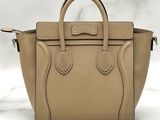 a beige leather handbag sitting on top of a marble counter