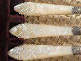 three pieces of carved ivory with silver in a box