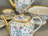 four pieces of tea and coffee set on a table