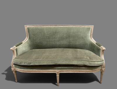 a green couch that is sitting on a gray surface