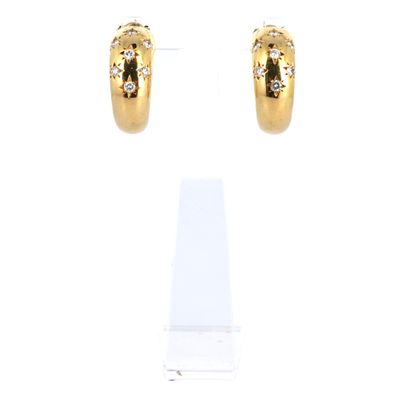gros plan d'une paire de boucles d'oreilles sur une surface blanche