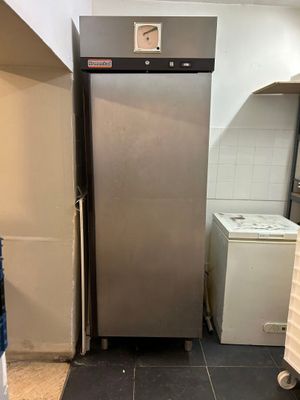 a stainless steel refrigerator in a kitchen with a washing machine