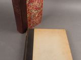 un vieux livre posé à côté d'un livre fermé sur une table