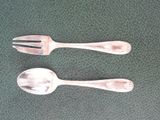 two spoons and a fork sitting on a table