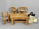 dolls sitting around a table with chairs and a table with a doll