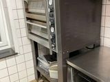 une cuisine équipée d'une cuisinière, d'un four et d'étagères