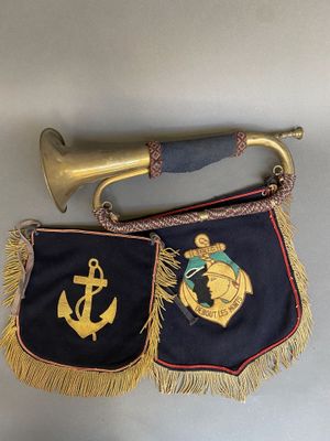 une vieille trompette en laiton et un vieux drapeau de la marine accrochés au mur