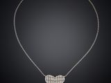 a diamond heart pendant on a chain on a black background