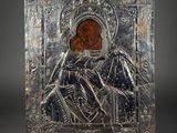an old silver metal plaque with an image of a woman holding a child