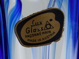 a blue glass vase with a brown label on it
