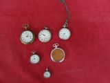 de nombreux modèles différents de montres de poche posés sur un tissu rouge