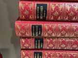 six red books stacked on top of each other on a shelf