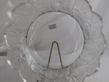 a glass plate with a gold stand on a white background