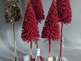 three small christmas trees sitting on top of a table next to each other