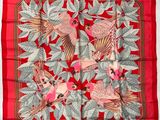 un gros plan sur une écharpe rouge ornée d'oiseaux
