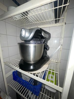 un mixeur posé sur une étagère dans une cuisine, à côté d'un évier