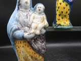 trois figurines en céramique représentant une femme tenant un enfant dans ses bras et un homme tenant un bébé