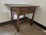 a small wooden table with a drawer on it