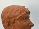 a clay sculpture of a woman ' s head on a table