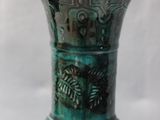 a green vase that is sitting on a table