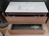 a white sink sitting on top of a wooden cabinet