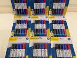 six packs of assorted pens are lined up on a table