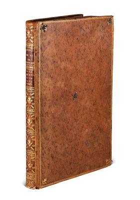 an old book with a brown leather cover and gold trim