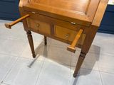 un petit bureau en bois surmonté d'un tiroir
