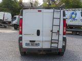a white van parked in a parking lot with a ladder on the back