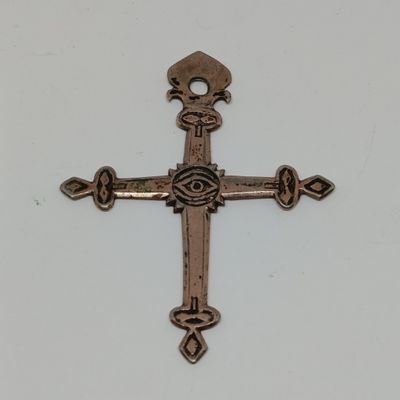 un gros plan d'une croix posée sur une table, sur fond blanc
