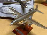 trois maquettes d'avions posées sur une table à côté d'un livre