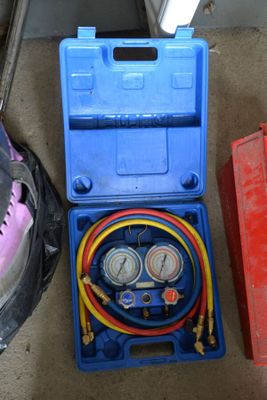 two air compressors and a tool box on the floor