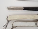 three different types of scissors and a pen on a table