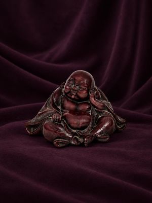 a small buddha statue sitting on top of a purple cloth