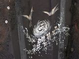 a black shirt with a picture of a bird and flowers on it
