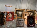 a table with a lot of picture frames and vases on it