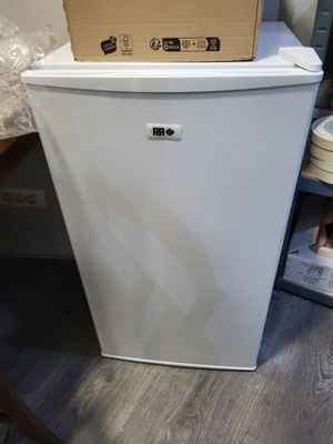 un réfrigérateur blanc sur lequel est posée une boîte