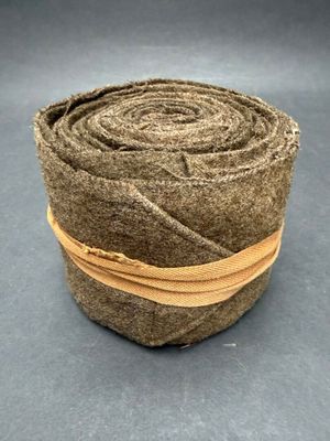 a close up of a roll of brown felt with a brown ribbon