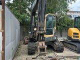 un engin de chantier garé à côté d'un bâtiment
