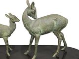 two statues of a deer and a fawn on a black base