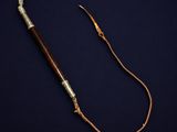 an old wooden stick with a metal handle on a dark background