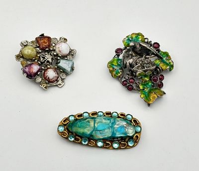 trois broches de formes et de couleurs différentes sur un fond blanc